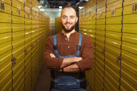 Téléchargez les photos : Tour de taille photo d'un homme joyeux debout dans la chambre forte derrière les casiers de stockage - en image libre de droit