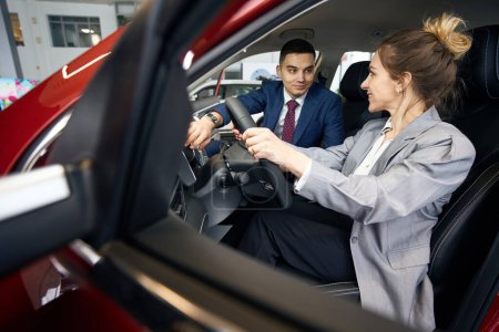 Foto de Hombre y mujer de negocios sentados en asientos delanteros en automóvil y mirándose el uno al otro - Imagen libre de derechos