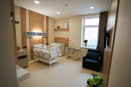 Téléchargez les photos : Salle d'hôpital vide avec lit bébé plusieurs meubles et TV plasma murale - en image libre de droit