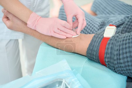 Foto de El médico con guantes protectores toma sangre de un paciente para un nuevo procedimiento de plasmolifting rejuvenecedor. - Imagen libre de derechos
