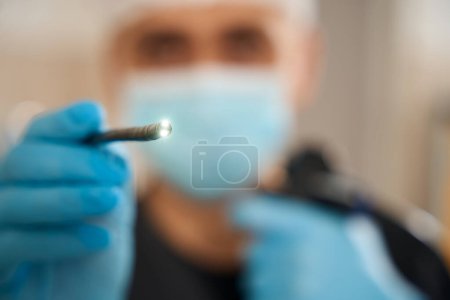 Téléchargez les photos : Mise au point sélective de l'extrémité distale de l'endoscope avec lentilles d'éclairage dans la main du médecin - en image libre de droit