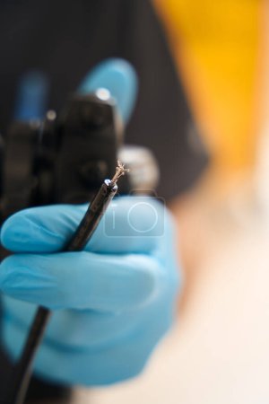 Téléchargez les photos : Gros plan de la main endoscopiste dans un gant jetable tenant une sonde endoscopique avec pince à biopsie - en image libre de droit