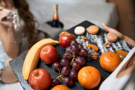 Photo for Fruits and sweets on the original tray. Healthy food in bed for a champagne snack - Royalty Free Image