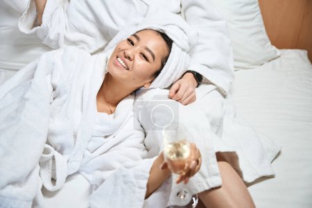 Foto de Las novias en una habitación de hotel se relajan con albornoces blancos. Las mujeres celebran felizmente un viaje para viajar. Foto recortada - Imagen libre de derechos