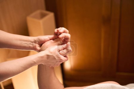 Photo for Cropped photo of qualified masseuse massaging palms of adult male client using thumbs - Royalty Free Image