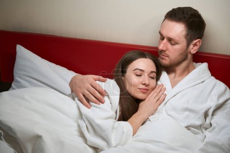 Foto de Serena joven caucásica mujer durmiendo en la cama en su amado hombre hombro - Imagen libre de derechos