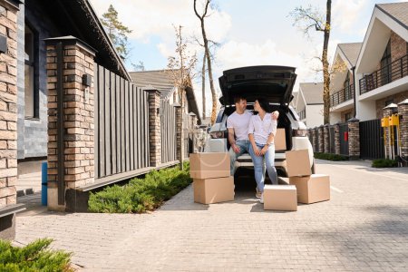 Photo for Caucasian man hugging his wife surrounded by boxes while moving - Royalty Free Image