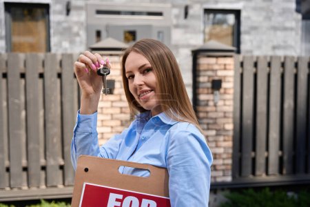 Téléchargez les photos : Femme tenant à vendre signe dans une main montre clés de maison - en image libre de droit