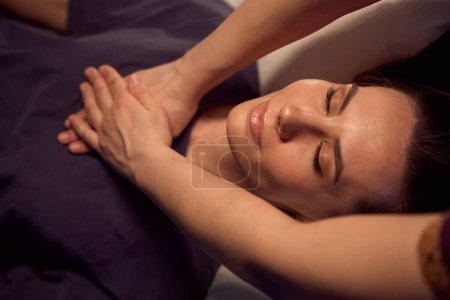 Foto de Primer plano de la paciente femenina acostada supina con los ojos cerrados mientras masoterapeuta masajea sus músculos del esternón - Imagen libre de derechos