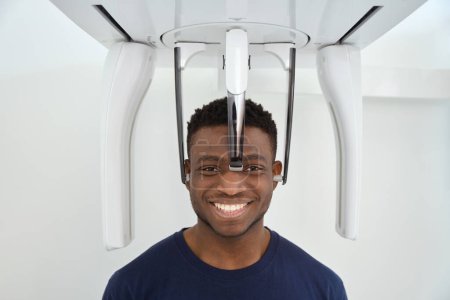 Foto de Paciente parado cerca del aparato de tomografía computarizada. Imagen tomográfica del cráneo y los dientes - Imagen libre de derechos