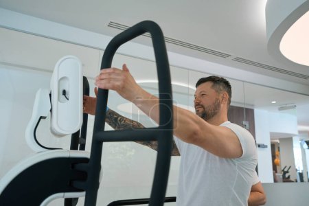 Téléchargez les photos : Homme caucasien adulte faisant de l'exercice sur plate-forme motorisée multi-axes à la salle de gym - en image libre de droit