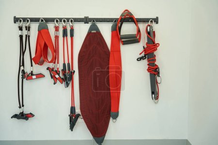 Foto de Conjunto de correas de entrenamiento de suspensión y eslingas colgadas en bastidor de gancho montado en la pared - Imagen libre de derechos