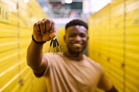 Téléchargez les photos : Afro-Américain se tient avec des clés dans des conteneurs de stockage, les cellules sont numérotées - en image libre de droit