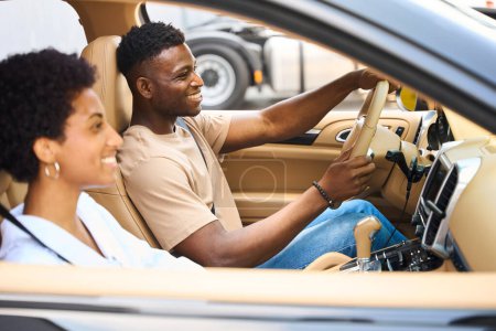 Photo for Cute African American couple is sitting in the car, the man is in the drivers seat - Royalty Free Image