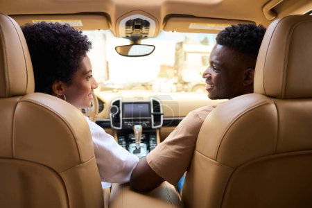 Téléchargez les photos : Beau couple marié afro-américain dans une voiture confortable, les conjoints se regardent avec tendresse - en image libre de droit