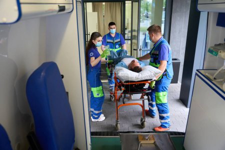Téléchargez les photos : Ambulance a livré la victime dans l'accident aux urgences, le patient reçoit un compte-gouttes avec des analgésiques - en image libre de droit
