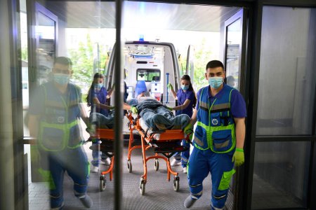 Foto de El equipo de ambulancia llevó al paciente al hospital, el personal médico trabaja con máscaras protectoras - Imagen libre de derechos