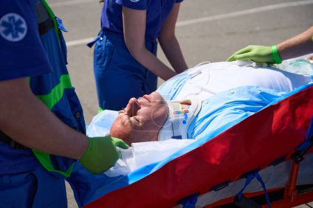 Téléchargez les photos : L'équipe ambulancière a posé le patient pour le transporter sur un matelas aspirateur, la victime a été mise sur un compte-gouttes - en image libre de droit