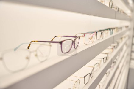 Foto de Escaparate con una amplia selección de monturas de gafas, iluminación decorativa utilizada - Imagen libre de derechos