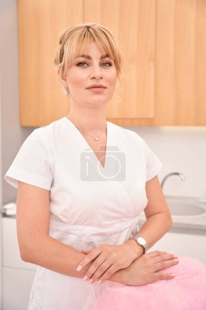 Foto de Mujer joven en su lugar de trabajo en una clínica de cosmetología, ella está en un uniforme limpio - Imagen libre de derechos