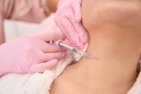 Photo for Patient receives beauty injections in the neck area, the specialist uses protective gloves - Royalty Free Image