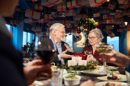 Foto de Alegre anciano hombre y mujer celebrando el Año Nuevo disfrutando de la fiesta en el restaurante - Imagen libre de derechos
