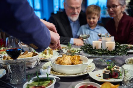 Téléchargez les photos : La famille assise à table au restaurant va écouter du poulet rôti tout en célébrant le jour de Thanksgiving ensemble - en image libre de droit