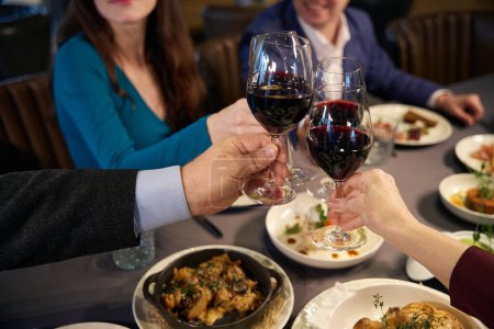 Téléchargez les photos : Couple assis à une table festive avec des verres de vin et des toasts - en image libre de droit