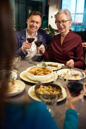 Foto de Feliz hombre y mujer sentados en el restaurante mientras celebran las vacaciones de invierno juntos - Imagen libre de derechos