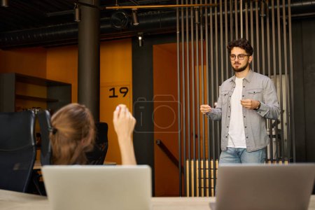 Photo for Young caucasian businessman and cropped businesswoman talking during work in coworking office. Concept of teamwork - Royalty Free Image