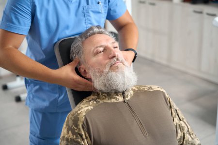 Foto de Male chiropractor works with a patient in a rehabilitation center, he gives him a massage - Imagen libre de derechos