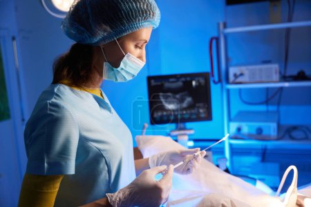 Seitenansicht einer Ärztin, die eine Spritze zur künstlichen Befruchtung in der Reproduktionsklinik einsetzt. Embryologie und Biotechnologie