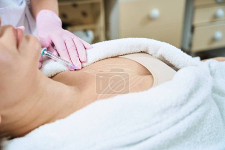Photo for Cropped image of female cosmetologist doing chest beauty injection with syringe of woman in blurred beauty salon. Body skin care, lifting and rejuvenation - Royalty Free Image