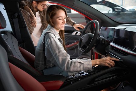 Téléchargez les photos : Homme et femme tester une nouvelle voiture pour l'achat de choisir l'automobile chez le concessionnaire - en image libre de droit