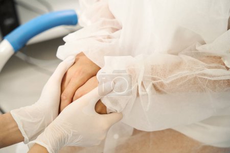 Foto de Primer plano de la doctora recortada y paciente mujer tomados de la mano en la clínica médica - Imagen libre de derechos