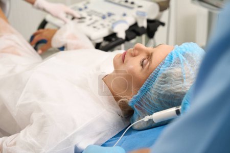 Téléchargez les photos : Image partielle du médecin avec seringue lors de l'examen d'une patiente enceinte en clinique reproductive. Concept de grossesse et de maternité - en image libre de droit