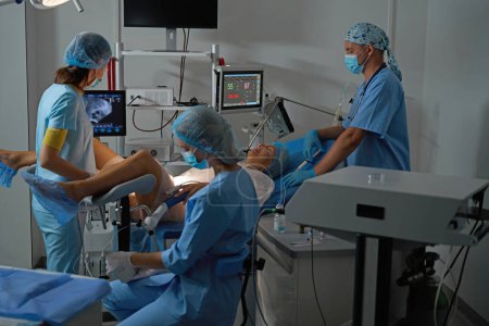 Téléchargez les photos : Le personnel de l'hôpital fait une échographie à la patiente caucasienne enceinte sur un équipement moderne avant l'accouchement en clinique de reproduction. Concept de grossesse et de maternité - en image libre de droit