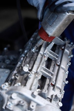 Foto de Persona con guantes de protección durante la reparación del motor de un coche moderno, un mecánico de automóviles utiliza herramientas especiales - Imagen libre de derechos