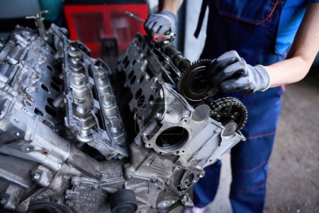 Foto de Reparación profesional del motor de un coche moderno, un mecánico de automóviles trabaja en guantes de protección - Imagen libre de derechos