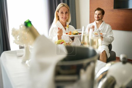 Téléchargez les photos : Les clients de l'hôtel prennent leur petit déjeuner dans leur chambre dans la zone de loisirs, le petit déjeuner est servi sur une table mobile - en image libre de droit