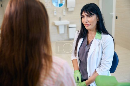 Téléchargez les photos : Gynécologue européenne adulte regardant une patiente partielle lors de son examen en clinique. Concept d'examen de grossesse - en image libre de droit