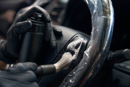 Foto de Especialista con guantes de protección lleva a cabo detallando dentro del coche, utiliza espuma de limpieza especial para la limpieza - Imagen libre de derechos