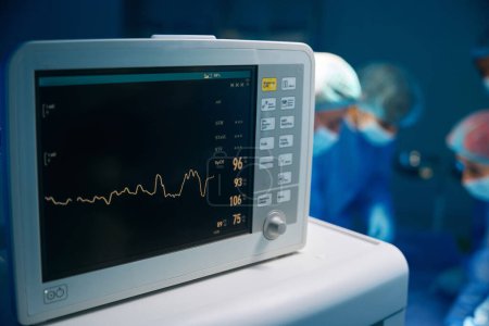 Téléchargez les photos : Rythme cardiaque et moniteur de contrôle du patient dans la salle de théâtre de l'hôpital pendant l'opération - en image libre de droit