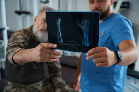 Téléchargez les photos : Homme dans la salle de gym regardant les rayons X, équipement moderne dans la chambre - en image libre de droit