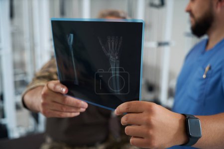 Foto de Doctor y un paciente miran las radiografías, hay equipos modernos en la habitación - Imagen libre de derechos