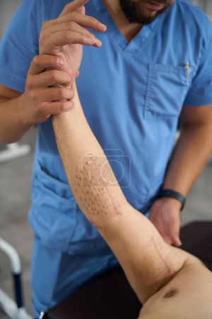 Téléchargez les photos : Chiropracteur consulte un homme en tenue militaire, le patient s'allonge sur une table de massage - en image libre de droit