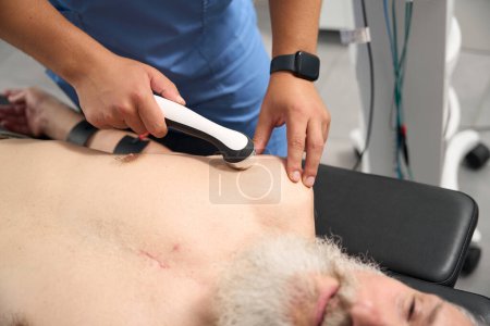 Photo for Man with scars on his body at a hardware therapy session, the doctor uses effective treatment methods - Royalty Free Image
