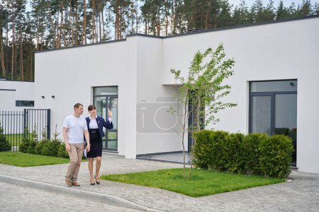 Käufer und Verkaufsleiter gehen durch den Hof eines neuen Hauses, Landschaftsplanung im Hof