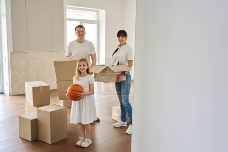 Téléchargez les photos : La famille heureuse déménage dans une nouvelle maison de campagne, les gens déménagent des boîtes avec des choses - en image libre de droit