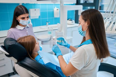 Girl at a dentists appointment in a modern clinic, the doctor works with an assistant